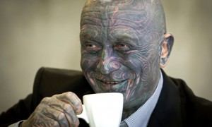 Facially tattooed man drinking coffee