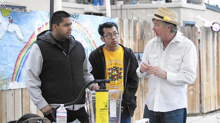 Denny Larson, right, an environmental expert, shows residents of the Oak View community how to build and operate a self-made air pump during a meeting on Friday in Huntington Beach. (Don Leach / Huntington Beach Independent)